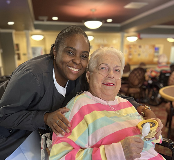 caregiver and senior woman smiling for the camera